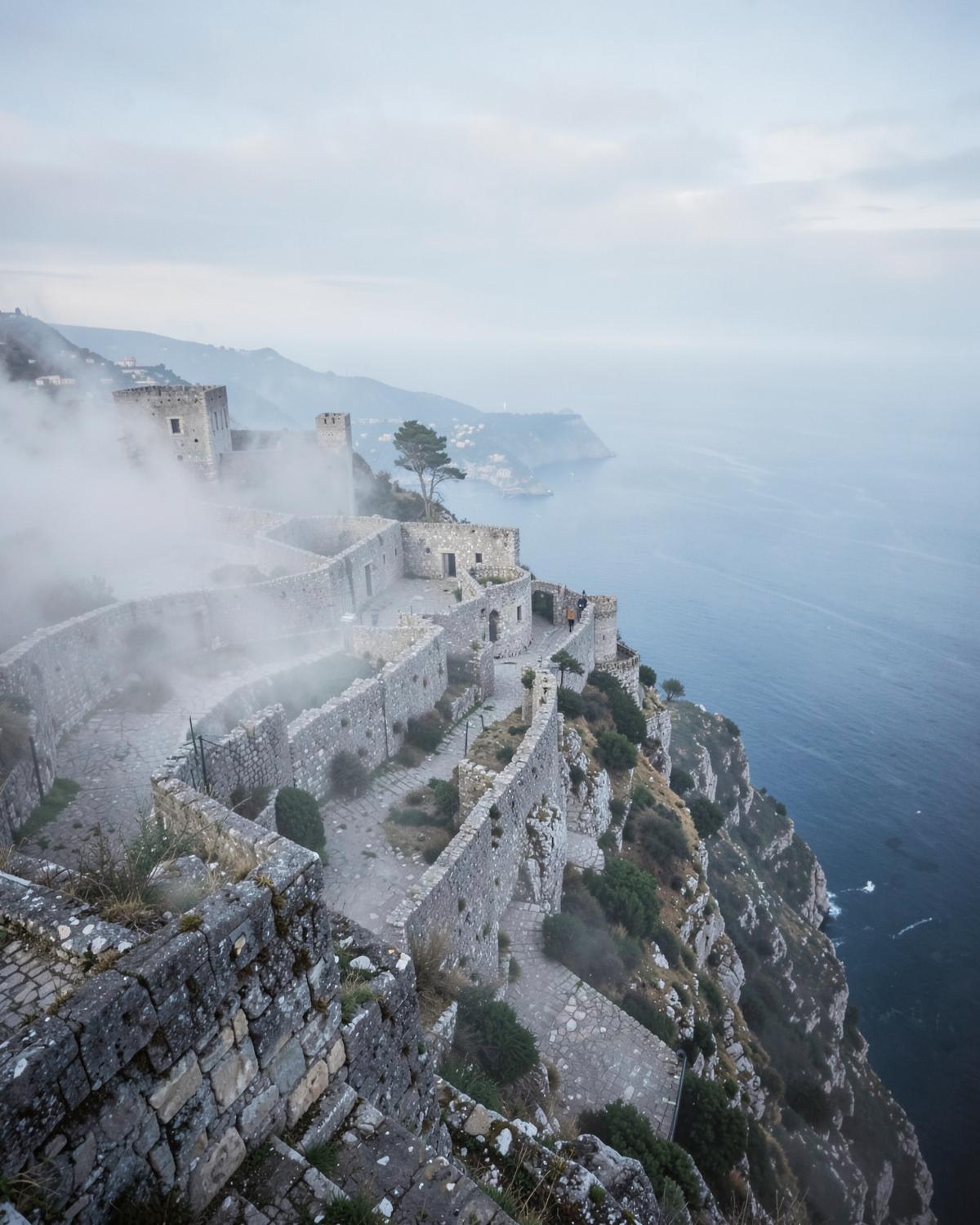 Medieval stone walls of Erice above the coast in the mist