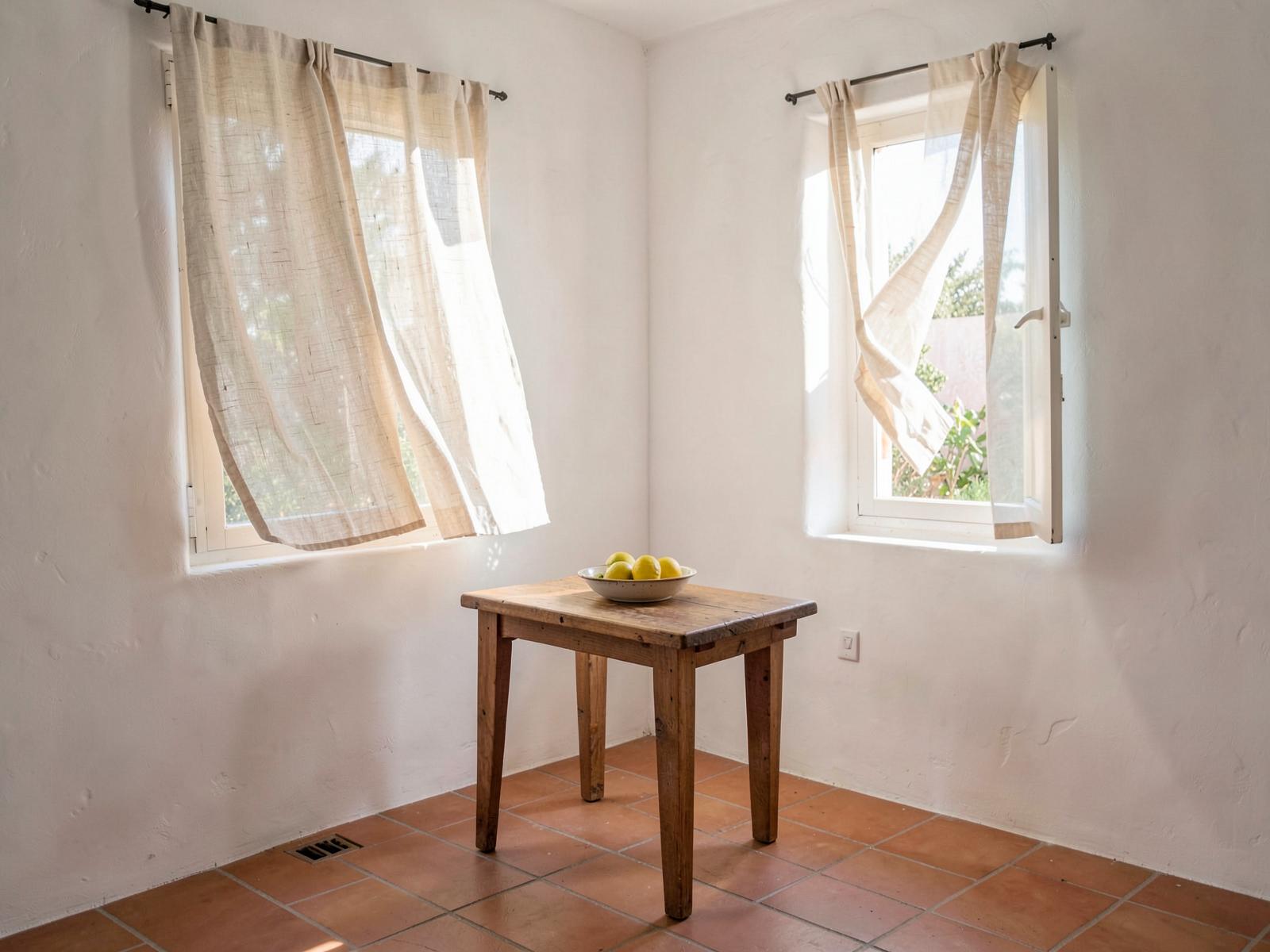 Placeholder photograph: light interior with linen curtains and terracotta floor